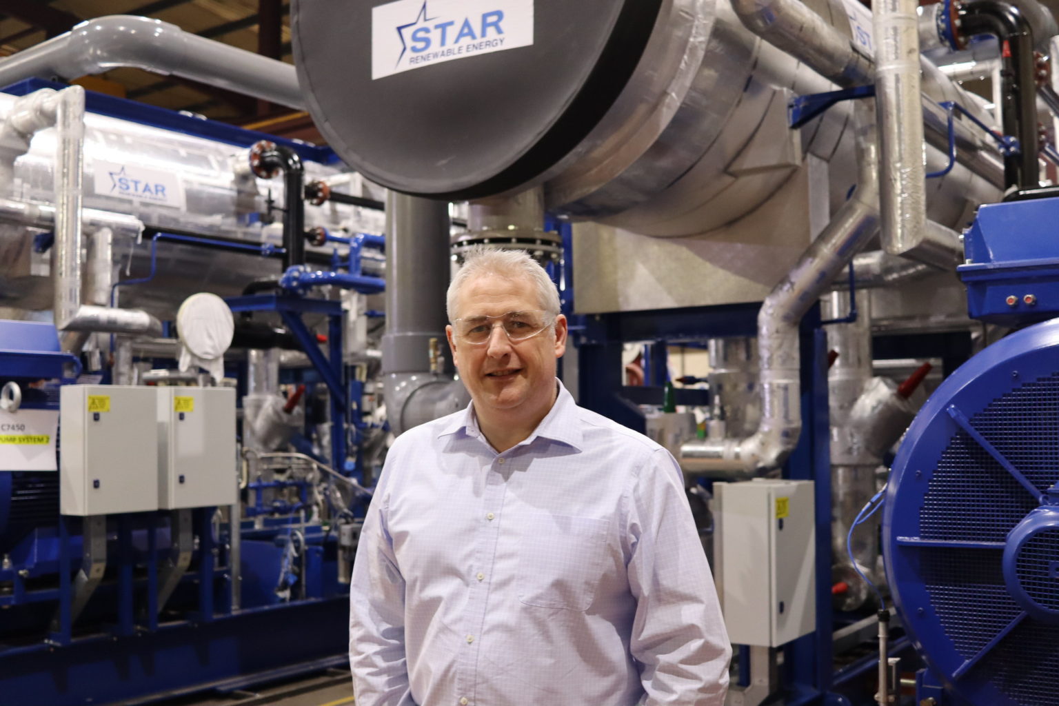 Dave Pearson next to water source heat pump